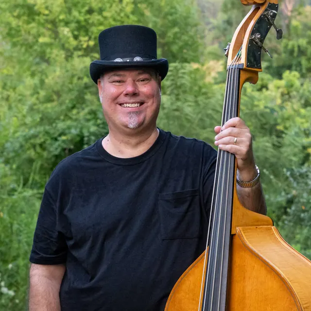 Ken Holley smiling beside his bass